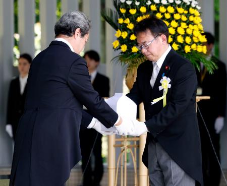 千鳥ケ淵戦没者墓苑で開かれた拝礼式で、新たに納骨する遺骨を受け取る上野厚労相＝２５日午後、東京都千代田区
