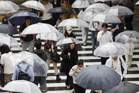 雨の中、傘を差して歩く人たち