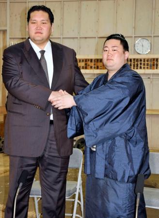 師匠の伊勢ケ浜親方（左）と握手する新十両の嵐富士＝東京都墨田区の伊勢ケ浜部屋