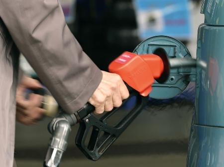 東京都内のセルフ式ガソリンスタンドで給油する客