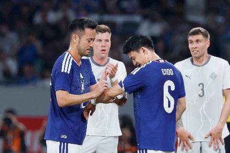 日本―アイスランド　前半、途中交代し、遠藤（６）にキャプテンマークを渡す吉田＝ＭＵＦＧスタジアム
