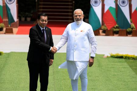 １日、インド・ニューデリーでモディ首相（右）と握手するミャンマーのミンアウンフライン氏（ロイター＝共同）