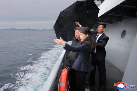試験航海する北朝鮮の新型５千トン級駆逐艦に乗船する金正恩朝鮮労働党総書記（左）と娘（手前）＝４日（朝鮮中央通信＝共同）