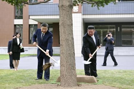 朝鮮労働党の幹部養成機関「中央幹部学校」で植樹する中国の習近平国家主席（手前左）と北朝鮮の金正恩朝鮮労働党総書記＝９日、平壌（新華社＝共同）