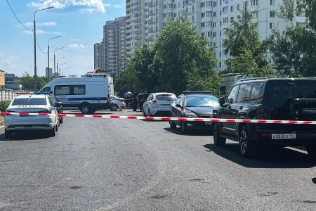 ９日、モスクワ東部郊外の自動車の爆発現場で規制線を張って調べる治安当局者ら（タス＝共同）