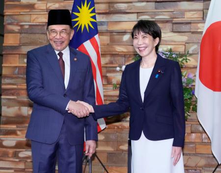 会談前に握手するマレーシアのアンワル首相（左）と高市首相＝１０日午前、首相官邸