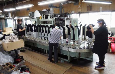 蒸気の圧力で靴下を整った形やサイズに仕上げる「セット機」＝５日、奈良県大和高田市