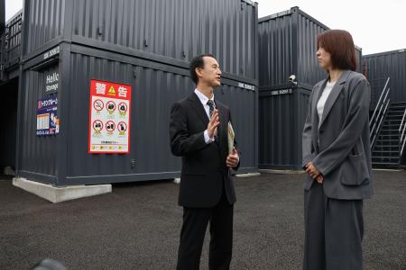 トランクルーム運営会社に情報提供を依頼する警視庁の担当者(左)=9日、東京都足立区