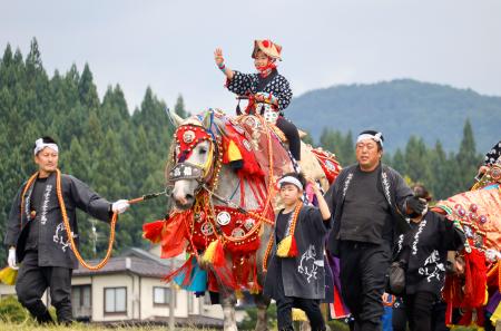 伝統行事「チャグチャグ馬コ」で子どもを背に行進する、きらびやかな装束で着飾った馬。鈴の音を響かせながらゆっくりと練り歩いた＝１３日午前、岩手県滝沢市