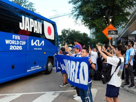 　オランダ戦の開催地、ダラスの宿舎に向かう日本代表を乗せたバスに声援を送るサポーターら＝１２日（共同）