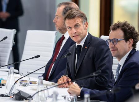 米アンソロピックのダリオ・アモデイＣＥＯ（手前）とＧ７サミットの昼食会に臨むフランスのマクロン大統領＝１７日、フランス東部エビアン（ロイター＝共同）