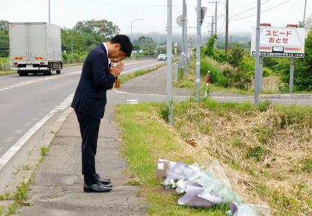 事故現場で献花し、手を合わせる「北都交通」の佐藤晃彦社長（手前）ら＝１８日午後、北海道八雲町