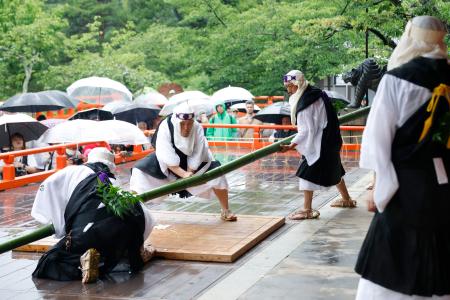 鞍馬寺の「竹伐り会式」で、大蛇に見立てた青竹をたたき切る僧兵姿の男性＝２０日午後、京都市左京区