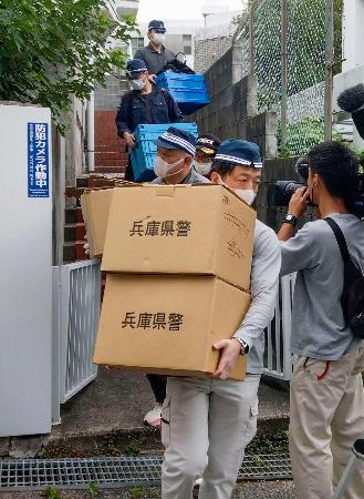 成人男性の遺体が見つかったマンションから段ボール箱を運び出す捜査員＝２１日午後５時１６分、神戸市中央区