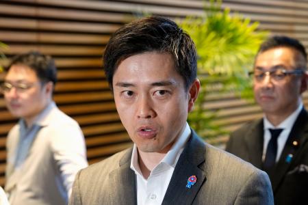 高市首相と会談後、記者団の取材に応じる日本維新の会の吉村代表。右奥は遠藤国対委員長＝２２日午後、首相官邸