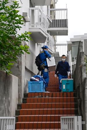 大型冷凍庫から成人男性の遺体が見つかったマンションに出入りする捜査員＝２２日午前、神戸市中央区