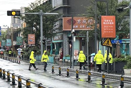 日本人学校の下校時間に、通学路を警戒する警察官＝２２日、中国江蘇省蘇州（共同）