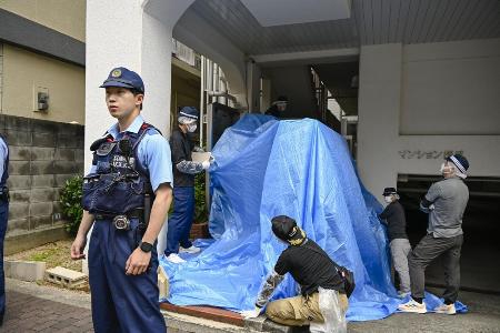男性の遺体が見つかったマンションを捜索する捜査員＝２１日午後、神戸市中央区
