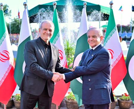 ２３日、パキスタンの首都イスラマバードで、シャリフ首相（右）に迎えられるイランのペゼシュキアン大統領（ロイター＝共同）