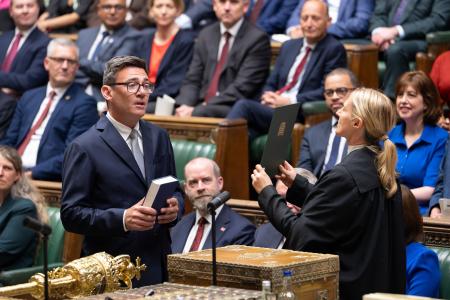 英下院議員として宣誓するバーナム前マンチェスター市長（手前左）＝２２日、ロンドン（下院提供、ＡＰ＝共同）