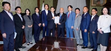 選挙運動に関するＳＮＳ対策に向けた法改正案を衆院の築山信彦事務総長（中央右）に提出する与野党の議員ら＝２４日午後、国会