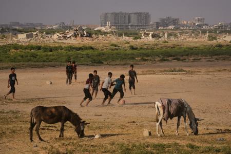 ２４日、ガザ中部ヌセイラトでサッカーをする子どもたち（ＡＰ＝共同）