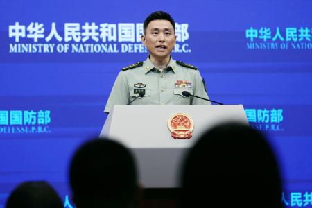 記者会見する中国国防省の張暁剛報道官＝２５日、北京（共同）