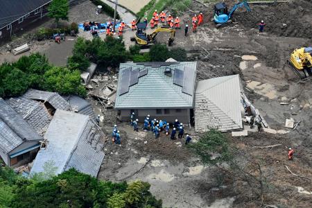 土砂崩れに巻き込まれた山口県平生町の住宅で、捜索と救助に当たる警察官ら＝２７日午前１１時３９分（共同通信社ヘリから）