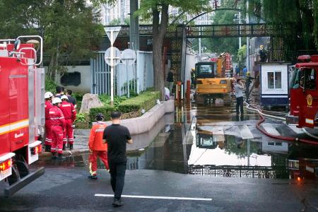 北京市朝陽区の火災現場付近に集まった消防隊員ら＝２７日（共同）