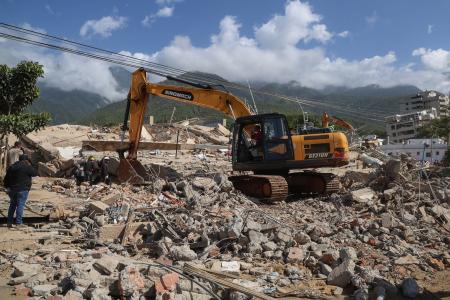 27日、ベネズエラの大地震後、倒壊した建物のがれきの中で被害者を捜索する救助隊(ゲッティ=共同)