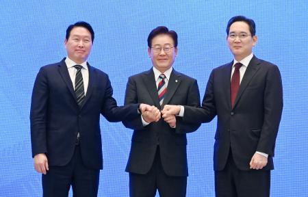 ２９日、韓国大統領府で開かれた国民報告会で撮影に応じる李在明大統領（中央）、サムスン電子の李在鎔会長（右）、ＳＫグループの崔泰源会長（共同）