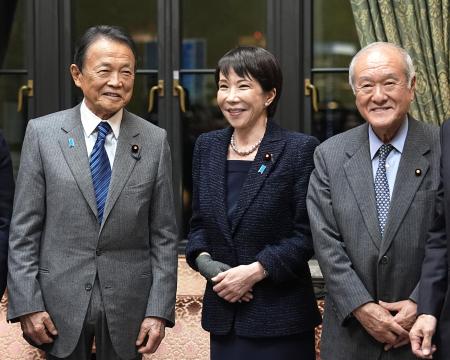 ２０２６年度予算案が衆院を通過後、自民党の麻生副総裁（左）と笑顔で言葉を交わす高市首相。右は鈴木幹事長＝３月１３日、国会