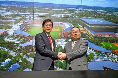 記者会見で握手するプロ野球日本ハムの栗山英樹ＣＢＯ（左）と北海道恵庭市の原田裕市長＝２日午前、エスコンフィールド北海道