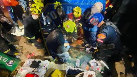 ２日、ベネズエラ・ラグアイラ州で男性の救出作業に当たる隊員ら（チリ消防当局提供・ゲッティ＝共同）