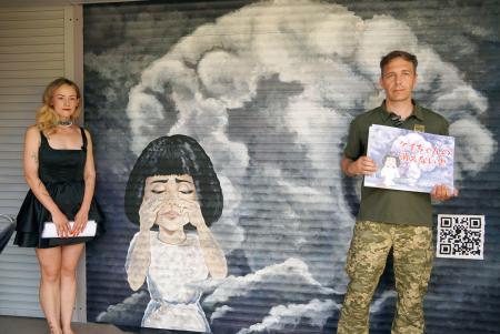 広島に原爆が投下された際のきのこ雲や少女の絵を描いたマクシム・リバルコさん（右）と妻アナスタシアさん＝２日、ウクライナ・キーウ（共同）