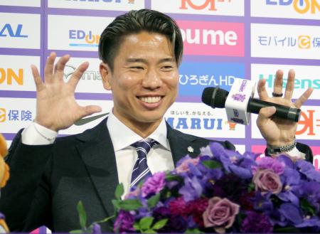 Ｊ１広島に復帰し、記者会見で得意のポーズを決める浅野拓磨＝３日、エディオンピースウイング広島