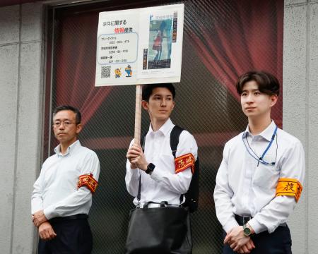 佐藤麻衣さんの事件について、情報提供を求めプラカードを掲げる茨城県警の警察官＝５日午後、埼玉県草加市