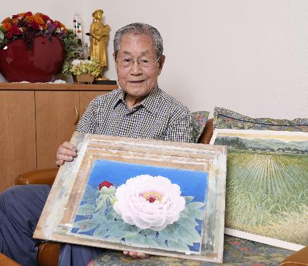 自作を手にする那波多目功一さん＝２０２４年１０月、東京都内
