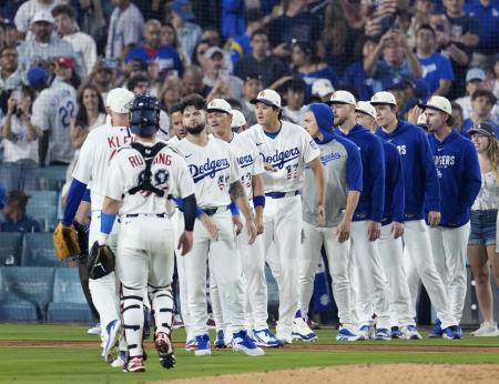４日、パドレスに勝利し、チームメートとタッチを交わすドジャース・大谷（中央、１７）＝ロサンゼルス（共同）