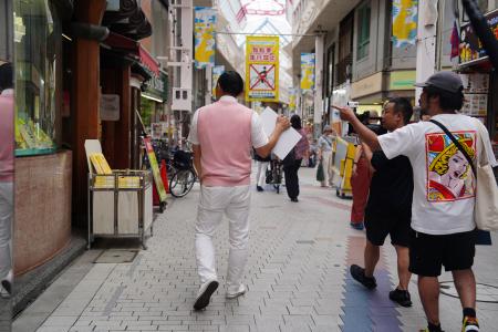 商店街を歩くオードリー春日。足取りが軽く、気を抜くと置いて行かれそうになる。