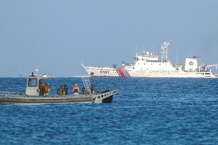 南シナ海・南沙諸島のパグアサ島沖をパトロールするフィリピン海兵隊のボート（手前）。中国海警局の艦船が見える＝５月３日（ゲッティ＝共同）