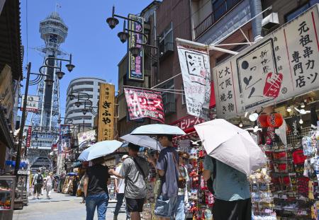 日傘を差して大阪・新世界を歩く人たち＝９日午後