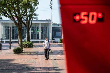 ６月２６日、熱波に見舞われたドイツ西部ドルトムントで、温度計の前を歩く男性（ゲッティ＝共同）