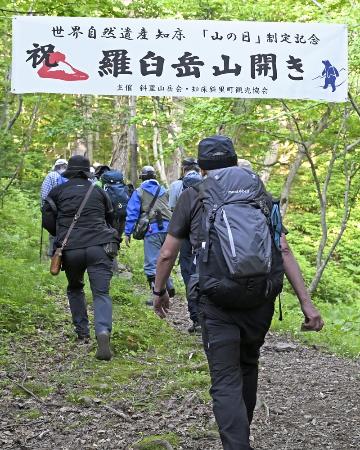 山開きが行われた羅臼岳の岩尾別登山口から登山に向かう人たち＝５日早朝、北海道斜里町