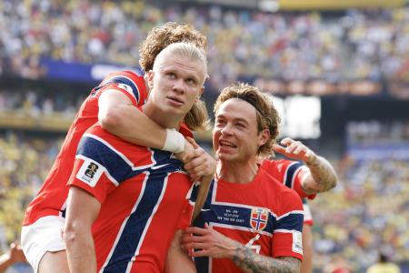 　決勝トーナメント２回戦のブラジル戦で、自身２点目のゴールを決め、祝福されるノルウェーのハーランド（左）＝５日、ニューヨーク（共同）