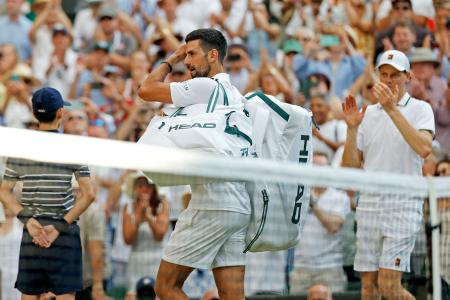 男子シングルス準決勝でヤニク・シナー（右端）に敗れ、引き揚げるノバク・ジョコビッチ＝ウィンブルドン（共同）