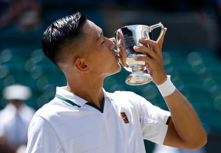 車いすの部男子シングルスで優勝し、トロフィーにキスする小田凱人＝ウィンブルドン（共同）