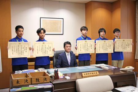 国際物理オリンピックでメダルを獲得した生徒たち。左から３人目は文科省の小林茂樹副大臣＝１４日午後、東京都千代田区