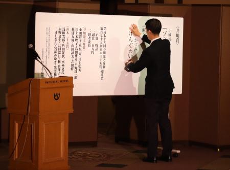 直木賞の受賞作を張り出す担当者。若林さんの落選が決まった瞬間だった=7月15日夜、東京都内