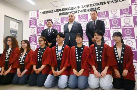 中京大との連携協定を締結し、学生（前列）らと記念写真に納まる日本相撲協会の八角理事長（後列中央）＝１９日、ＩＧアリーナ